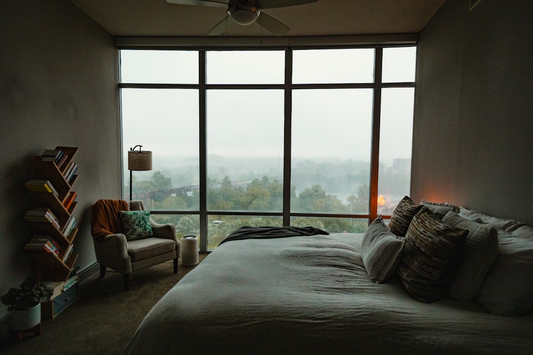A person awake at night near a window, representing disrupted sleep from frequent urination