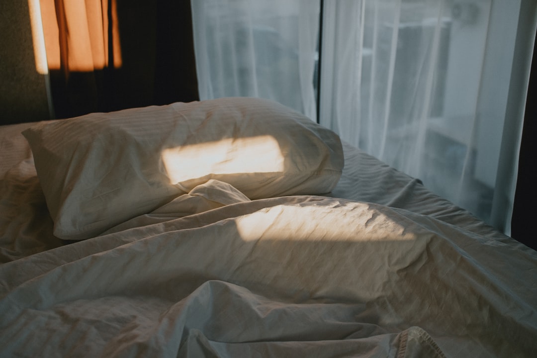 A person awake at night near a window, representing disrupted sleep from frequent urination