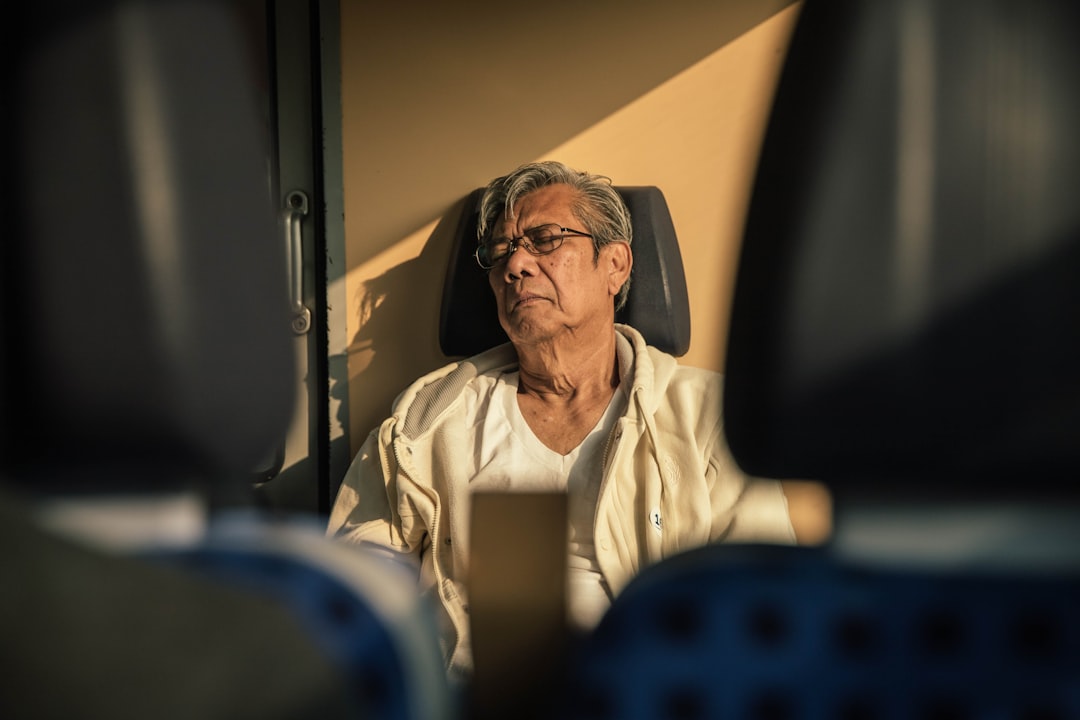 A person awake at night near a window, representing disrupted sleep from frequent urination