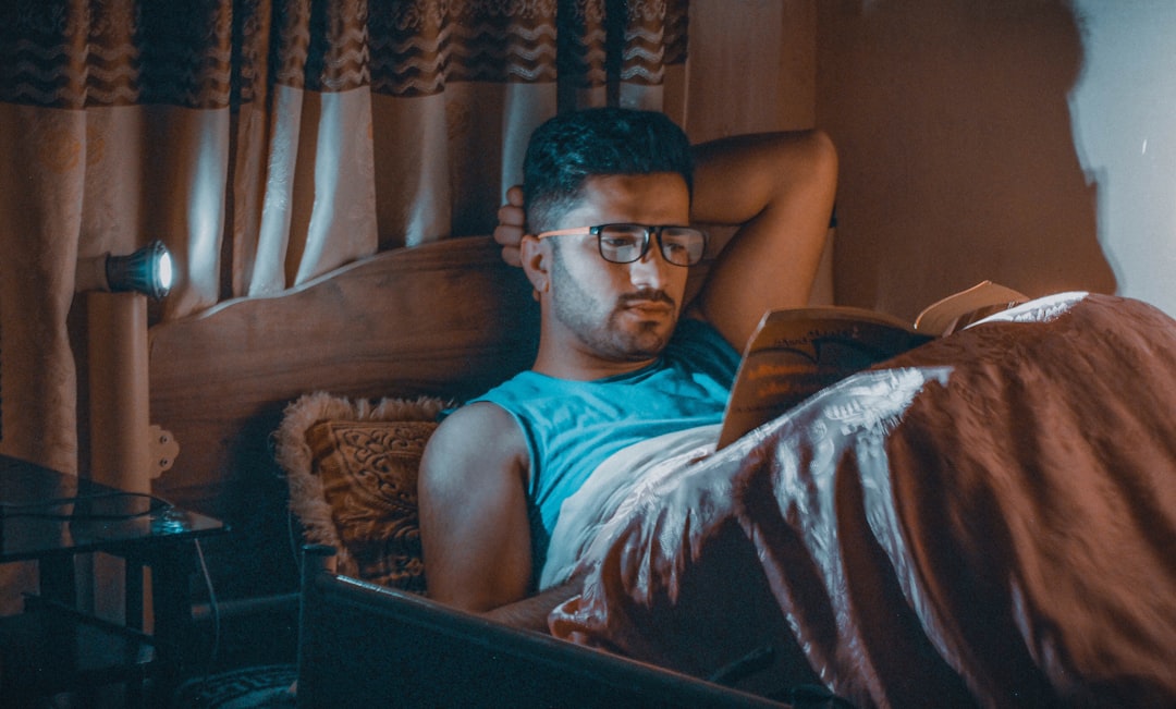 A person awake at night near a window, representing disrupted sleep from frequent urination