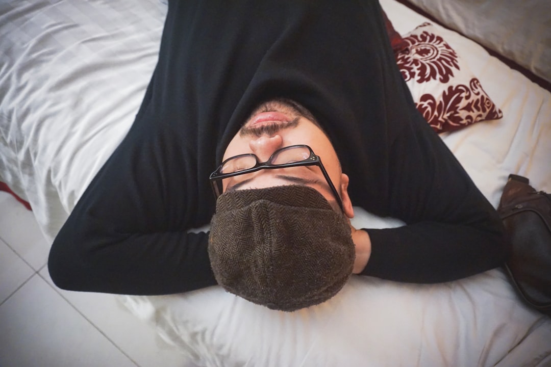 A person awake at night near a window, representing disrupted sleep from frequent urination